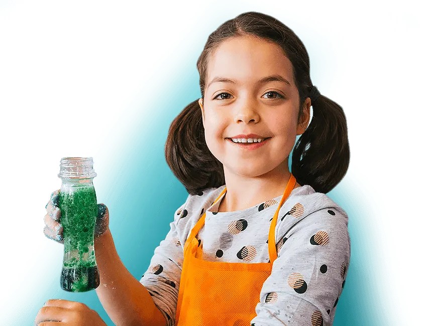 A girl smiling and holding a green bubbling volcano