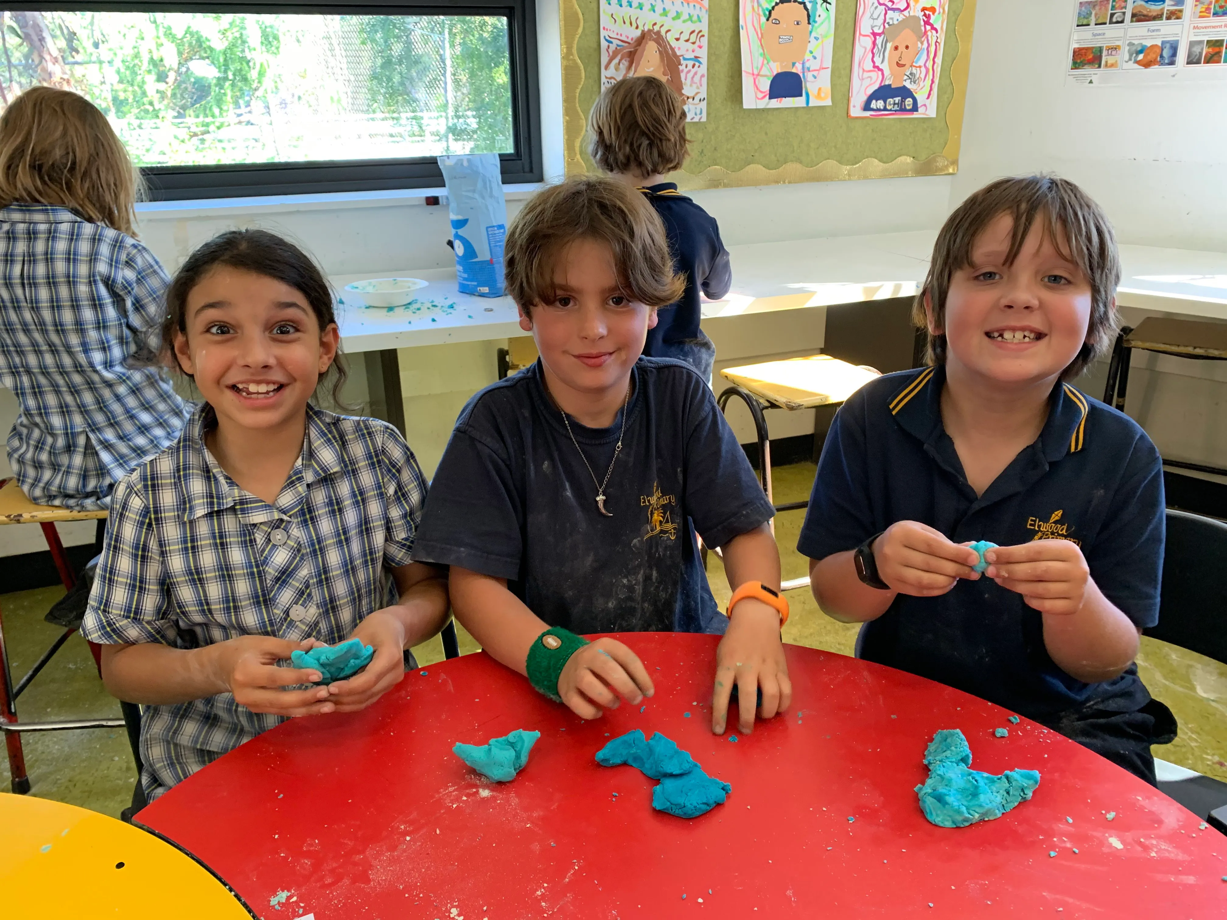 3 children smiling and moulding their experiment