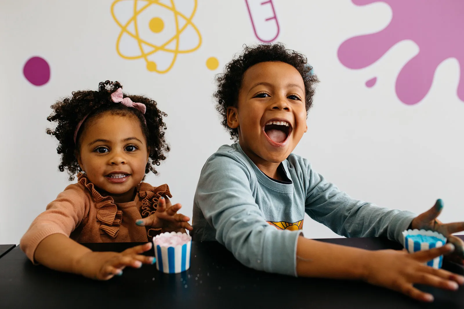 Two kids laughing with bath bombs