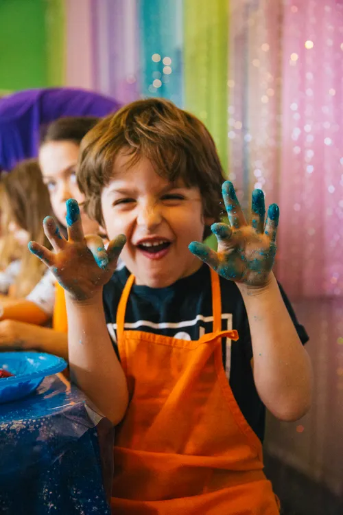 A kid with blue hands laughing