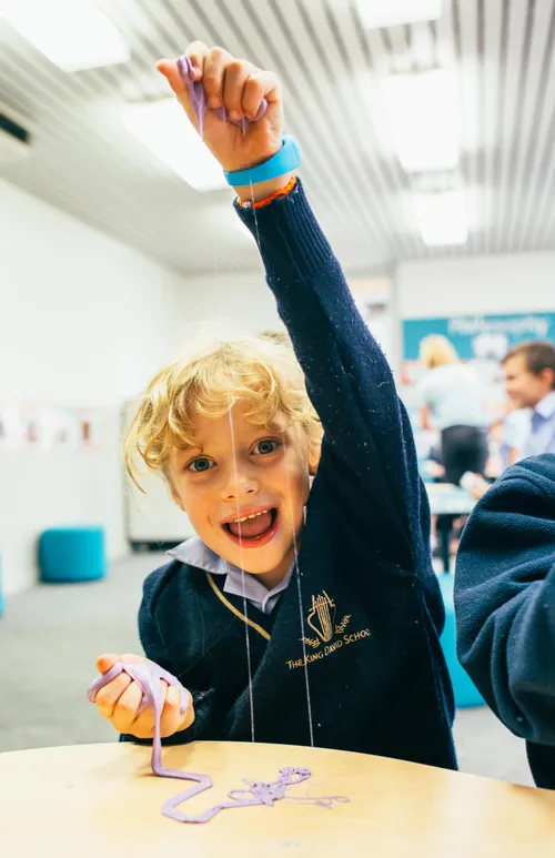 smiling child holding up slime