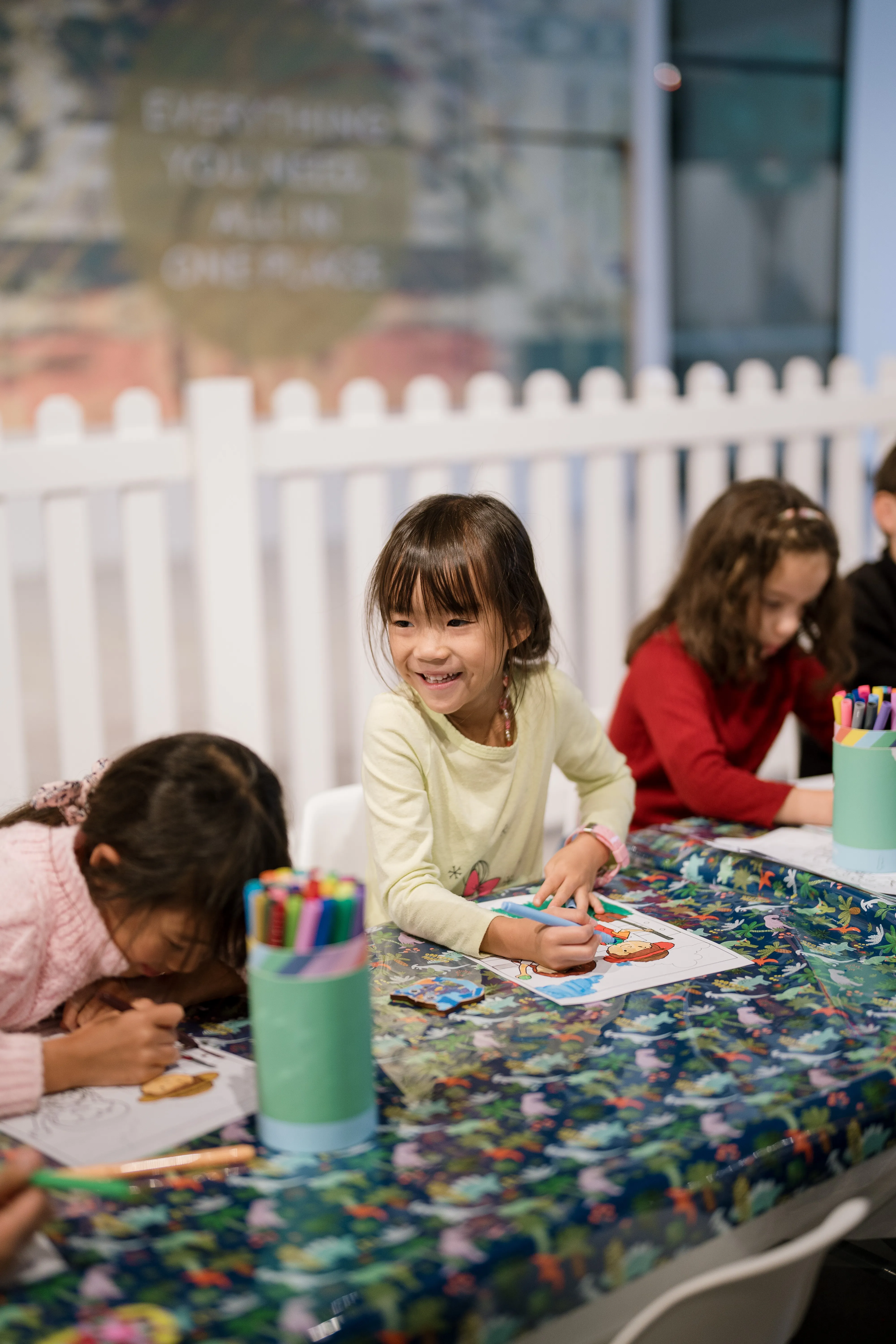 A child smiling while drawing with crayons