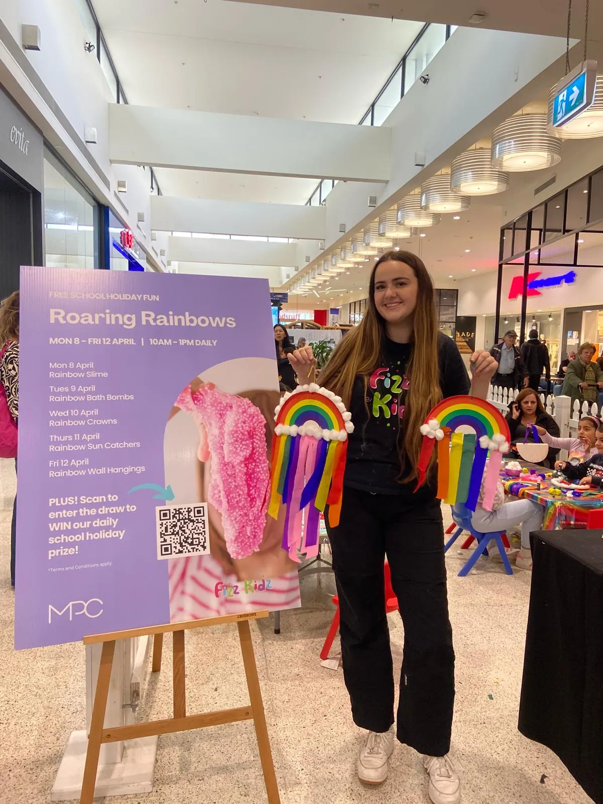 A Fizz Kids staff holding crafted rainbows